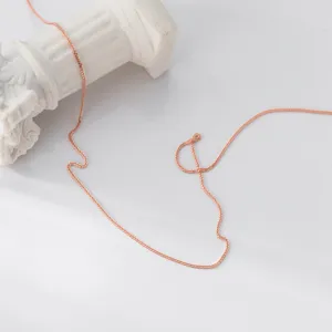 Primer plano detallado de un collar de plata esterlina rosa sobre accesorio blanco.