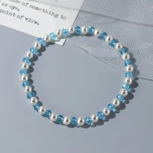 Détail de bracelet de perles et cristal bleu, accessoire de bijoux élégant au design de niche.