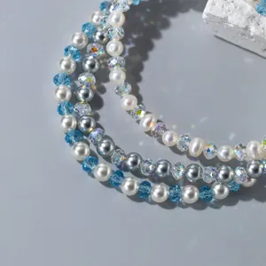 Bracelet de perles multi-brins élégant avec perles blanches, cristaux bleus et perles argentées.