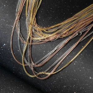 Nahaufnahme von mehrfarbigen, geschichteten Metallketten in Gold, Silber und Roségold.