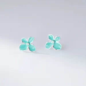 Mint green four-petal flower silver stud earrings detail view minimalist style