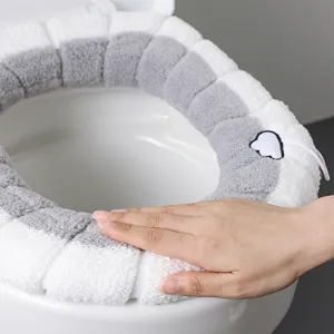 Funda de asiento de inodoro de felpa gruesa forma O gris y blanco, presentación táctil principal.