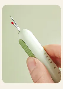 Close-up of portable seam ripper detail showing metal hook and red safety tip for sewing.