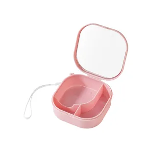 Portable pink storage box with mirror and compartments for travel jewelry and small cosmetics.