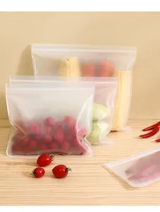 Detail view of frosted plastic food storage bags with fresh vegetables on wood table.