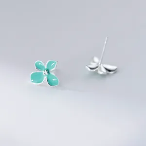 Close-up detail of mint green four-petal flower stud earrings with sterling silver posts.