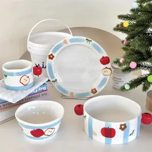 Cute ceramic tableware set with blue stripes and red apple details, perfect for home dining.