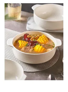 White ceramic double-eared soup bowl detail view, elegant textured kitchen tableware.