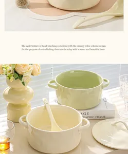 Cremekleurige keramische soepkom met tweekantige handgrepen in detail, prachtig servies thuis.