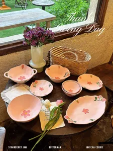 Vista dettagliata di un set di ciotole in ceramica rosa con motivi floreali e di fragole.