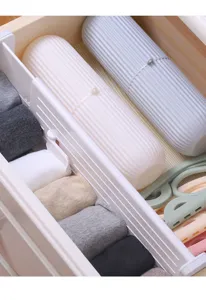 Detail shot of adjustable drawer divider and storage box organizing socks neatly inside a cabinet.