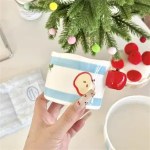 Cute ceramic coffee mug with blue stripes and apple handle, showcasing lovely detail design.