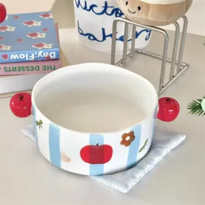 Ceramic apple bowl detail view, cute blue stripe design with red apple handles and underglaze.