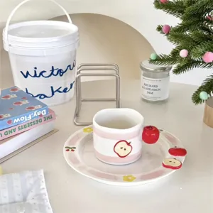 Ceramic mug and saucer set with cute pink stripes and 3D apple design for home use.