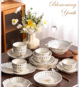 Detalle de vajilla cerámica francesa, elegantes cuencos y platos rayados en la mesa.