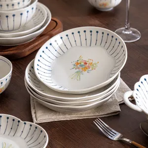 Juego de vajilla de cerámica de lujo francés con rayas azules y diseño floral elegante.