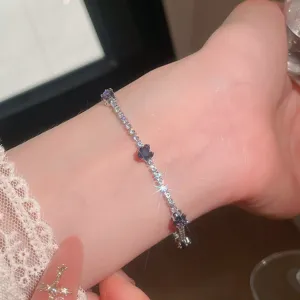 Vista detallada de pulsera de trébol de cristal con diamantes de imitación brillantes.