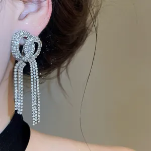 Crystal rhinestone tassel earring close-up, sparkling long drop design for evening party elegance.