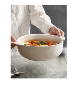 Detail view of a white ceramic double-ear soup bowl with elegant ribbed texture holding food.