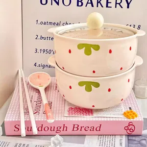 Detail view of cute ceramic bowl set with lid and spoon, pink strawberry pattern for noodle soup.