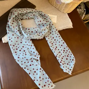 Detailed view of the light blue polka dot chiffon scarf with elegant french style.
