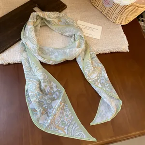 Detailed view of French country floral print chiffon scarf, elegant green border.