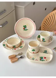 Set di stoviglie in ceramica con simpatici cartoni animati, piatti, ciotole e posate.