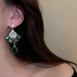Nahaufnahme Detail von Vintage Kristall Blumen Quasten Ohrringen, elegantes grünes Perlen Design.