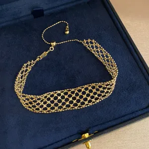 Close-up detail of the vintage gold mesh chain bracelet, showcasing delicate woven texture.