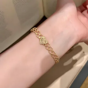 Gold filigree heart bracelet close-up, intricate beaded chain detail for vintage jewelry look.