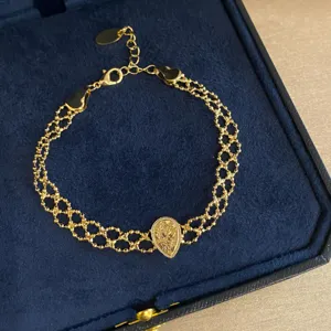 Close-up detail of vintage multi-strand mesh chain bracelet with teardrop pendant in box.