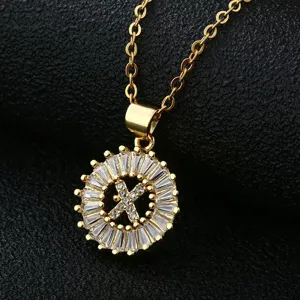 Vogue gold-plated brass necklace with round baguette cubic zirconia letter X pendant detail.