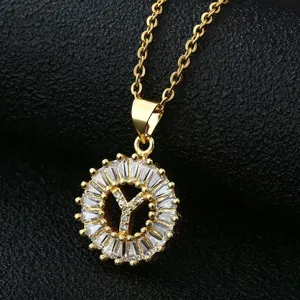 Detailed close-up of a gold-plated circular pendant necklace with sparkling cubic zirconia.