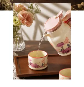 Détail d'un service à eau en céramique à motif floral, théière et tasse élégante.