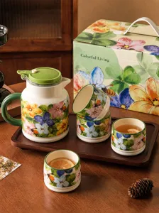 Ceramic tea set with kettle, cups, wooden tray and gift box, elegant floral design home decor.