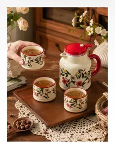 Ceramic teapot and teacup set detail view with floral pattern on wooden tray in cozy scene