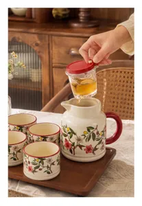 Ceramic tea set pitcher with cups, elegant floral pattern, cozy home lifestyle detail shot.