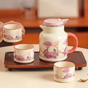 Service à thé en céramique élégant avec plateau en bois, théière et tasses à fleurs.