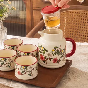 Ceramic teapot and teacup set with floral botanical pattern on a wooden tray for home use.