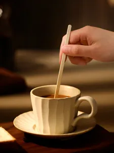 Close-up detail of natural bamboo coffee stirrer in cup for hot drinks and milk tea use.