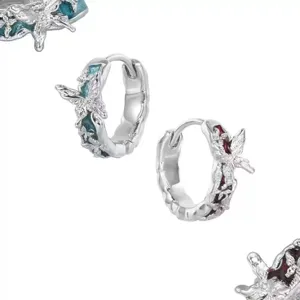 Detail view of the silver hoop earrings showcasing intricate butterfly and enamel work.