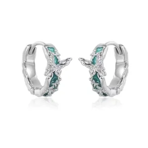 Detailed view of silver hoop earrings featuring mint green butterfly motif and sparkling clear stones.