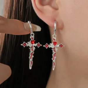 Orecchini a croce gotica con cuore rosso e rose. Vista di dettaglio degli orecchini in argento.
