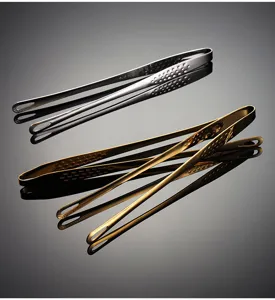 Stainless steel food tongs detail shot, showing silver and gold variants with drainage holes.