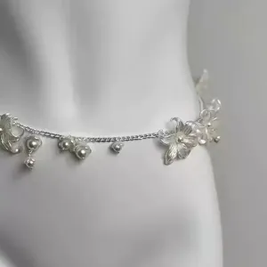 Elegante catena da cintura in argento con perle delicate e ciondoli floreali chic.