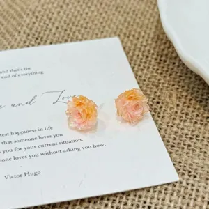Close-up of delicate multi-color floral stud earrings, exquisite detail showing sweet style.