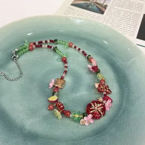 Gros plan détaillé d'un collier de perles colorées à fleurs sur une assiette en céramique.