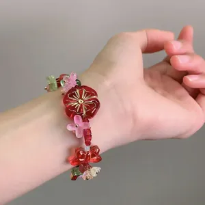 Gros plan détaillé du bracelet de perles florales colorées avec un design de fleurs et de nœuds.