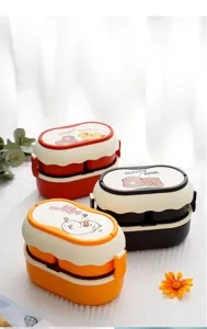 Gros plan de boîtes à bento empilables à compartiments avec des motifs d'animaux de dessin animé.