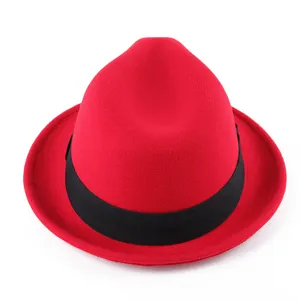 Primer plano y detalle del sombrero fedora de lana roja con fina textura de fieltro y cinta negra.